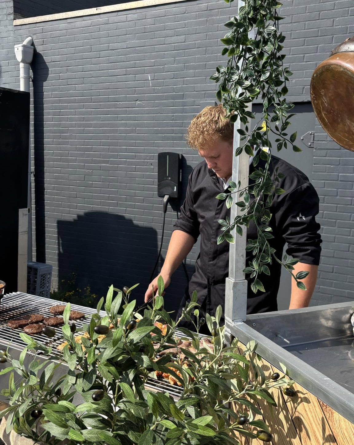 Chef grilt hamburgers op buitenbarbecue