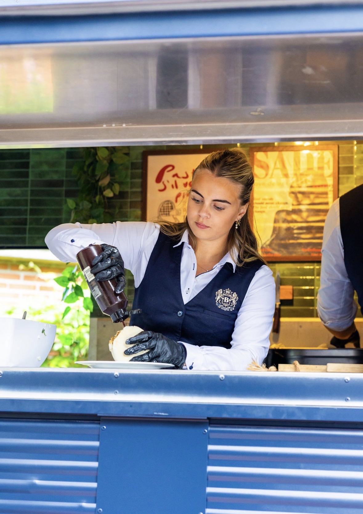 Barista naast mobiele koffiekar met espressomachine
