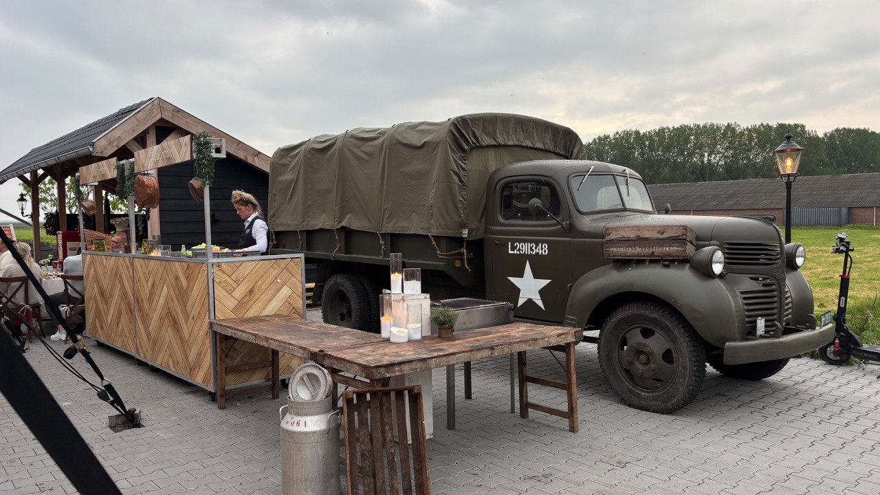 Vintage legertruck naast houten buitenbar