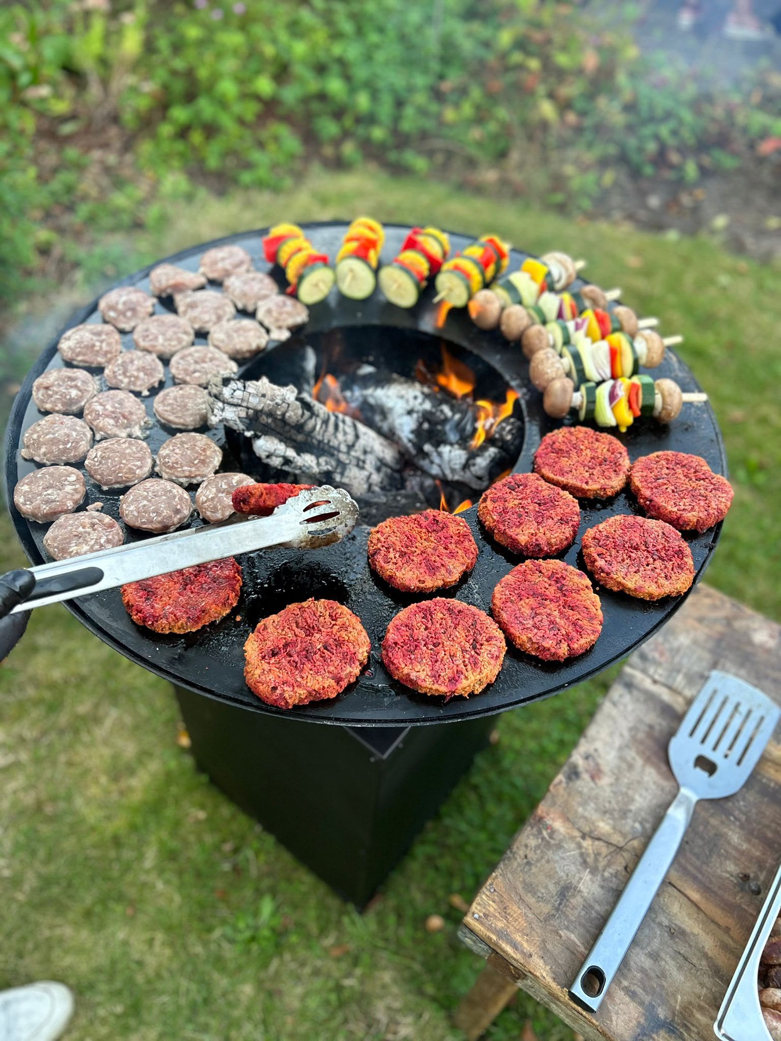 Barbecue met burgers en groentespiesjes op vuurplaat