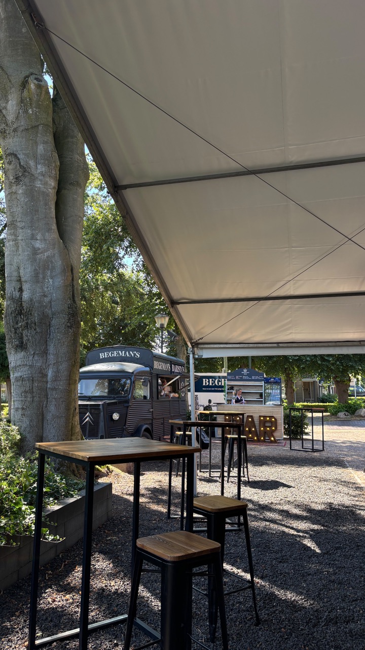 Overdekt terras met foodtruck en hoge tafels
