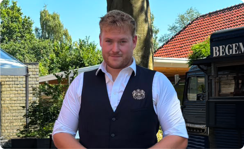 Man in gilet staat buiten bij horecawagen